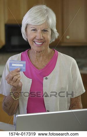 Portrait of a senior woman holding a credit card View Large Photo Image Stock Photo - Portrait of a senior woman holding a credit card. Fotosearch