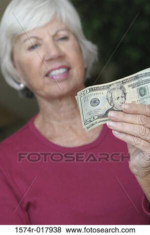 Portrait of a senior woman holding money View Large Photo Image Stock Photo - Portrait of a senior woman holding money. Fotosearch