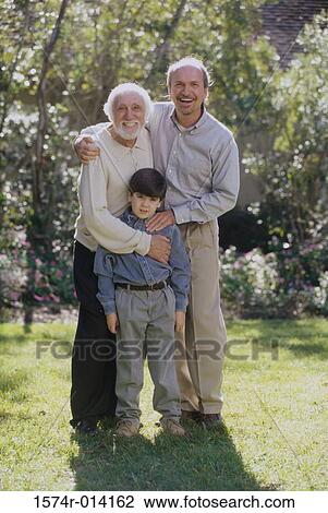 Stock Image - Portrait of a son standing with his father and grandfather smiling. Fotosearch