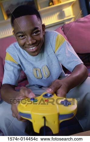 Stock Image - Portrait of a teenage boy playing video games. Fotosearch