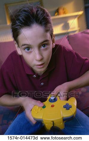 Stock Image - Portrait of a teenage boy playing video games. Fotosearch