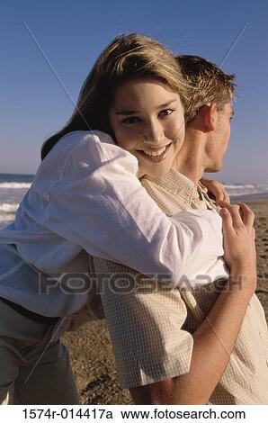 Portrait of a teenage girl embracing a teenage boy from behind View Large Photo Image Stock Image - Portrait of a teenage girl embracing a teenage boy from behind. Fotosearch