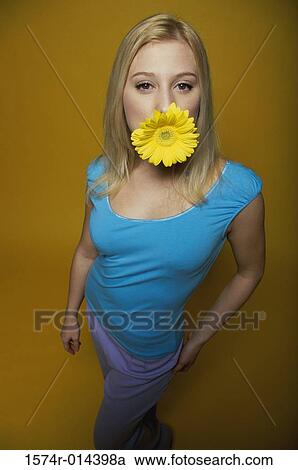 Portrait of a teenage girl holding a sunflower in her mouth View Large Photo Image Stock Image - Portrait of a teenage girl holding a sunflower in her mouth. Fotosearch
