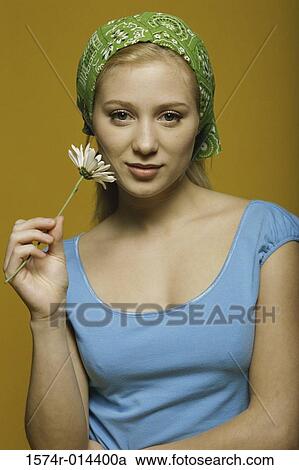 Stock Image - Portrait of a teenage girl holding a flower. Fotosearch