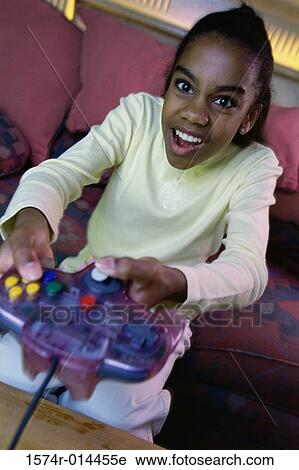Portrait of a teenage girl playing video games View Large Photo Image Stock Image - Portrait of a teenage girl playing video games. Fotosearch