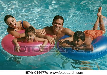 Portrait of a young couple in a swimming pool with their son and daughter View Large Photo Image Stock Image - Portrait of a young couple in a swimming pool with their son and daughter. Fotosearch