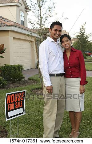 Portrait of a young couple standing on the lawn of a house smiling View Large Photo Image Stock Image - Portrait of a young couple standing on the lawn of a house smiling. Fotosearch