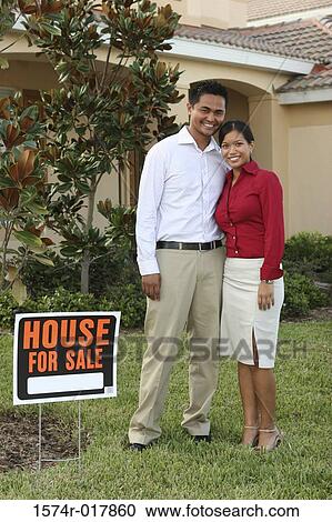 Portrait of a young couple standing on the lawn of a house smiling View Large Photo Image Stock Image - Portrait of a young couple standing on the lawn of a house smiling. Fotosearch