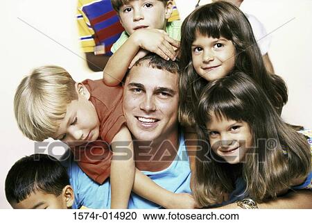 Portrait of a young man posing with children View Large Photo Image Stock Image - Portrait of a young man posing with children. Fotosearch