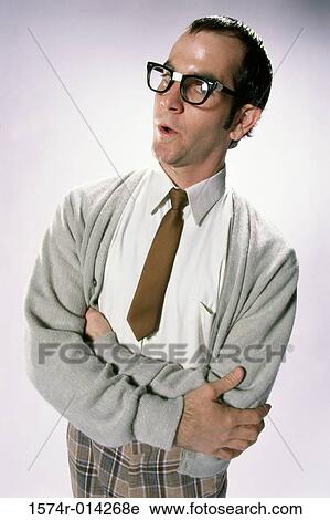 Stock Image - Portrait of a young man standing with his arms crossed. Fotosearch