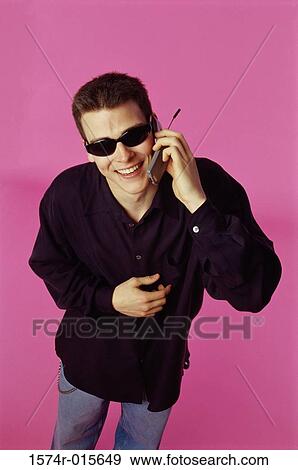 Stock Photo - Portrait of a young man talking on a mobile phone. Fotosearch