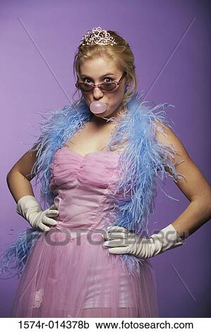 Stock Image - Portrait of a young woman blowing bubble gum. Fotosearch