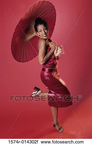 Portrait of a young woman holding a parasol View Large Photo Image Stock Image - Portrait of a young woman holding a parasol. Fotosearch