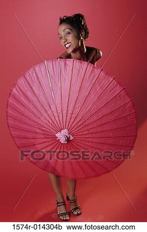 Portrait of a young woman holding a parasol View Large Photo Image Stock Image - Portrait of a young woman holding a parasol. Fotosearch