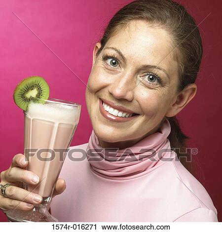 Portrait of a young woman holding a milk shake View Large Photo Image Stock Image - Portrait of a young woman holding a milk shake. Fotosearch