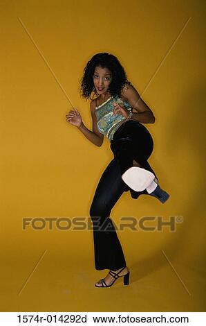 Portrait of a young woman kicking View Large Photo Image Stock Image - Portrait of a young woman kicking. Fotosearch