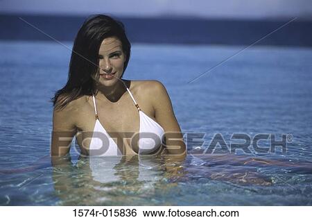 Stock Photograph - Portrait of a young woman lying on the beach. Fotosearch