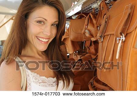 Portrait of a young woman smiling in a store View Large Photo Image Stock Image - Portrait of a young woman smiling in a store. Fotosearch