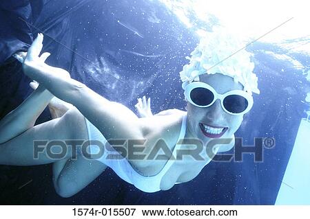 Portrait of a young woman swimming underwater View Large Photo Image Stock Photo - Portrait of a young woman swimming underwater. Fotosearch