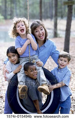 Portrait of a young woman with four children screaming on a tire swing View Large Photo Image Stock Image - Portrait of a young woman with four children screaming on a tire swing. Fotosearch