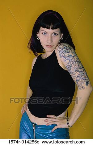 Stock Image - Portrait of a young woman with tattoos on her arms. Fotosearch