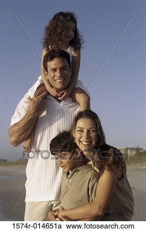 Stock Image - Portrait of parents and their two children on the beach. Fotosearch