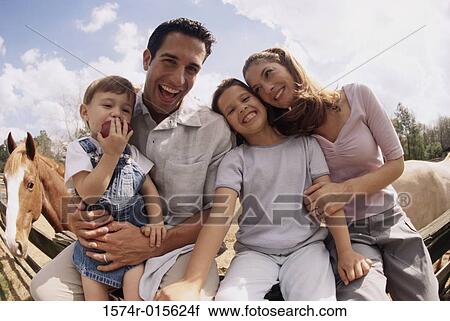 Stock Image - Portrait of parents sitting with their son and daughter. Fotosearch