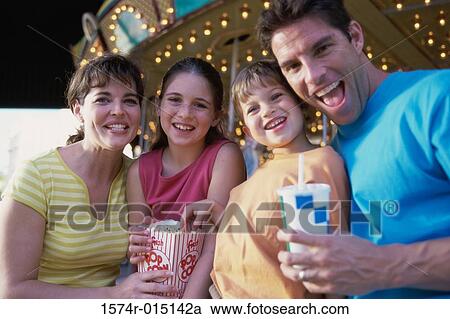 Stock Image - Portrait of parents with their son and daughter in an amusement park. Fotosearch