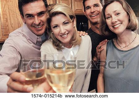 Portrait of two mid adult couples toasting at a party View Large Photo Image Stock Image - Portrait of two mid adult couples toasting at a party. Fotosearch