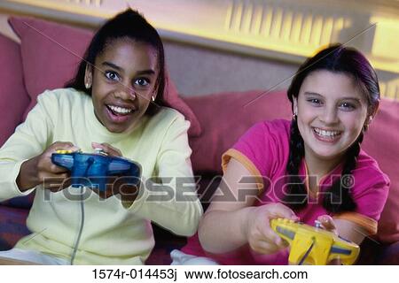Portrait of two teenage girls playing video games View Large Photo Image Stock Image - Portrait of two teenage girls playing video games. Fotosearch