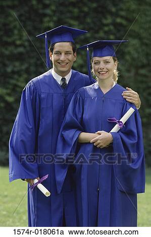 Stock Image - Portrait of two young graduates standing together in a garden. Fotosearch