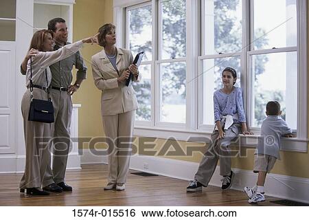 Real estate agent showing a house to a family View Large Photo Image Stock Photograph - Real estate agent showing a house to a family. Fotosearch