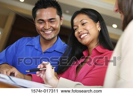 Real estate agent talking to a young couple View Large Photo Image Stock Image - Real estate agent talking to a young couple. Fotosearch
