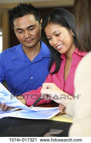 Real estate agent talking to a young couple View Large Photo Image Stock Image - Real estate agent talking to a young couple. Fotosearch