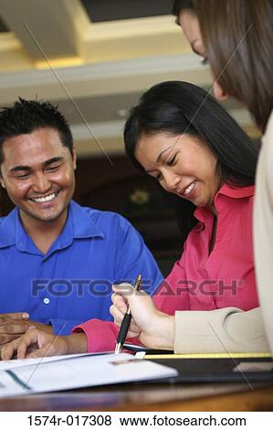 Real estate agent talking to a young couple View Large Photo Image Stock Photo - Real estate agent talking to a young couple. Fotosearch