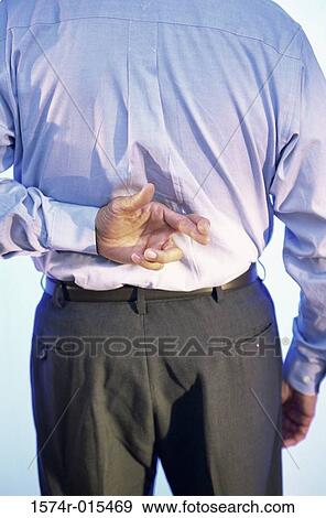 Stock Photo - Rear view of a businessman with his fingers crossed behind his back. Fotosearch