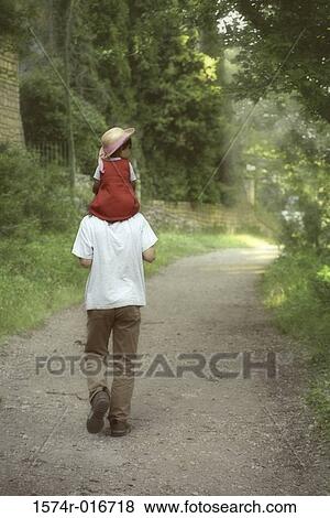 Rear view of a father carrying his daughter on his shoulders View Large Photo Image Stock Photo - Rear view of a father carrying his daughter on his shoulders. Fotosearch