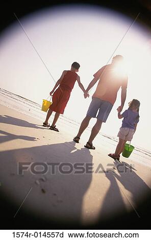 Rear view of a father with his son and daughter standing on the beach View Large Photo Image Stock Image - Rear view of a father with his son and daughter standing on the beach. Fotosearch