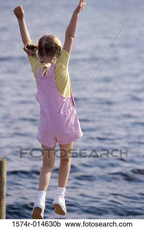 Rear view of a girl raising her arms on the beach View Large Photo Image Stock Image - Rear view of a girl raising her arms on the beach. Fotosearch