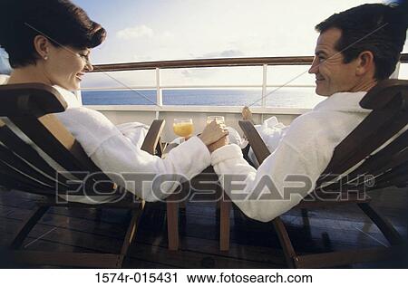 Rear view of a mid adult couple sitting in deck chairs on a cruise ship View Large Photo Image Stock Image - Rear view of a mid adult couple sitting in deck chairs on a cruise ship. Fotosearch