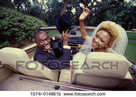 Rear view of a newlywed couple sitting in a convertible car View Large Photo Image Stock Image - Rear view of a newlywed couple sitting in a convertible car. Fotosearch