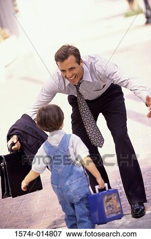 Rear view of a son running towards his father View Large Photo Image Stock Photo - Rear view of a son running towards his father. Fotosearch