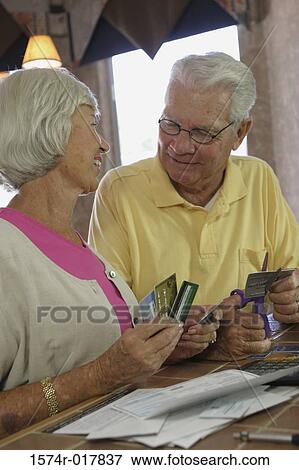 Stock Photo - Senior couple destroying credit cards. Fotosearch