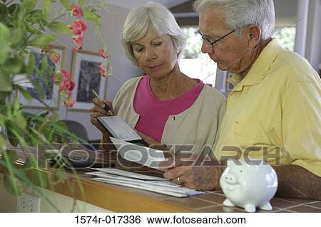 Senior couple reading a bill View Large Photo Image Stock Photograph - Senior couple reading a bill. Fotosearch