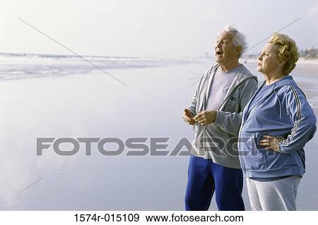 Senior couple standing on the beach View Large Photo Image Stock Photo - Senior couple standing on the beach. Fotosearch