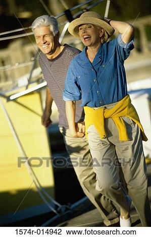 Stock Image - Senior couple walking on a boat. Fotosearch