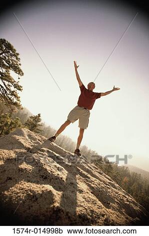 Stock Image - Senior man standing with his hands in the air. Fotosearch
