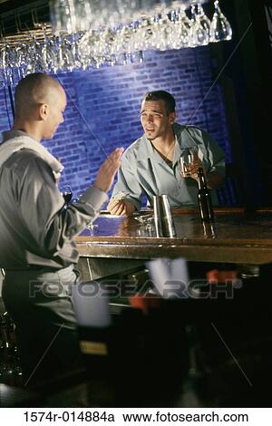 Side profile of a bartender refusing a drink to a young man View Large Photo Image Stock Image - Side profile of a bartender refusing a drink to a young man. Fotosearch