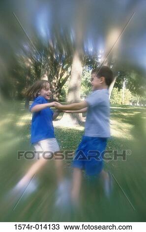 Side profile of a boy and girl swinging on a lawn View Large Photo Image Stock Image - Side profile of a boy and girl swinging on a lawn. Fotosearch