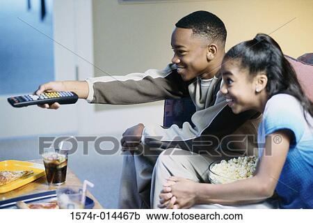 Side profile of a brother and sister watching television View Large Photo Image Stock Image - Side profile of a brother and sister watching television. Fotosearch